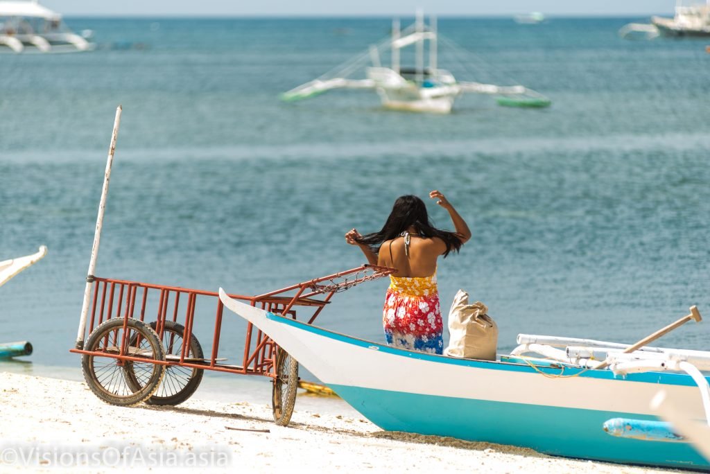 A lady dries her hair after a toss in the sea