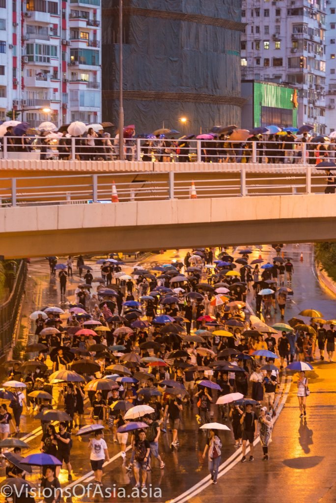 Protesters criss cross with an overpass.