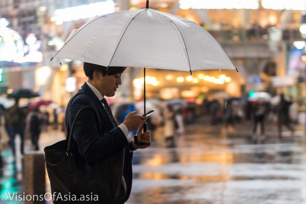 A salary man texts on his phone in Shibuya