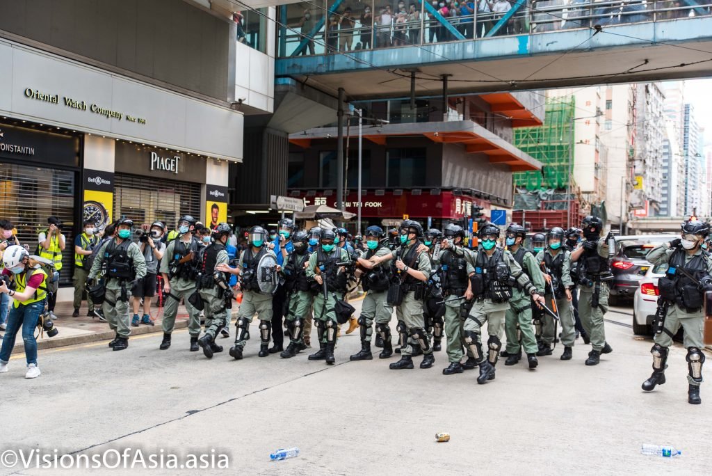 Riot police retreat as projectiles are thrown