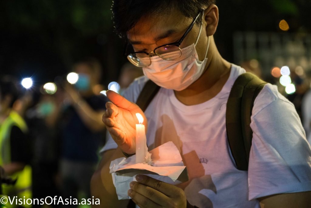 A young man holds a flickering light