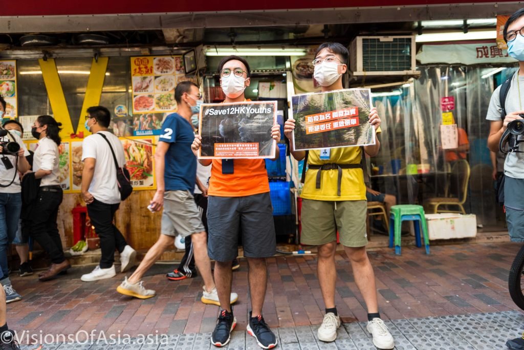 Two protesters hold posters "save hk 12"
