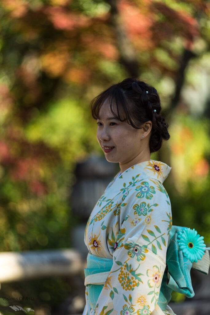 A Chinese lady in kimono poses on a bridge in Kyoto.