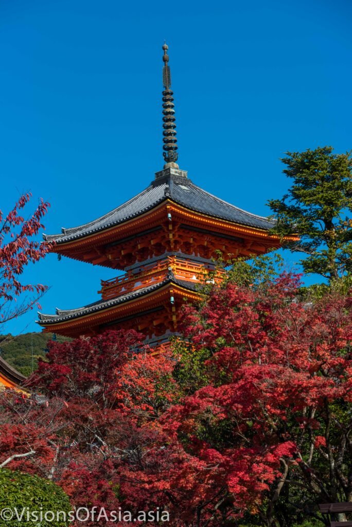 A temple pagoda surrounded by fall foliage