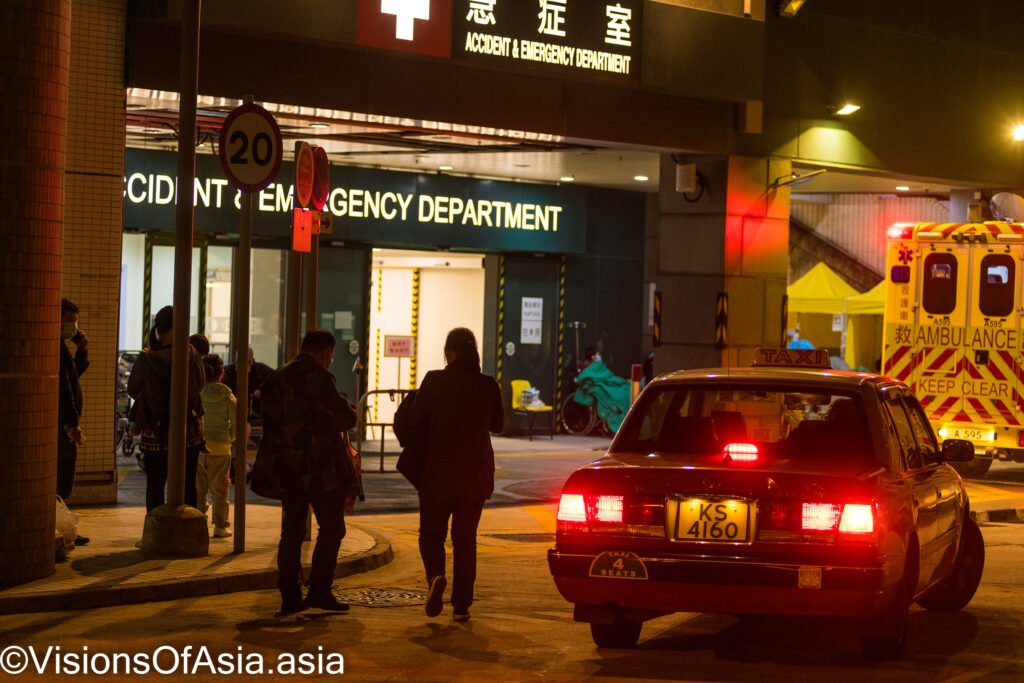 Patients arrive by taxi at the Accident and Emergency ward of the Caritas Medical Centre in Sham Shui Po, Hong Kong. The temperatures were predicted to reach lows of 13° C in the morning. Patients had to be hosted outdoors as hospitals in Hong Kong have been overwhelmed with the omicron outbreak.
