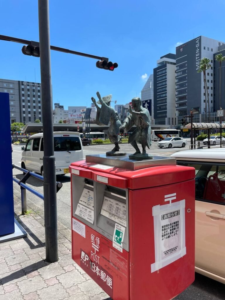 Statue of Awa Odori dancers on a mailbox of Tokushima station.